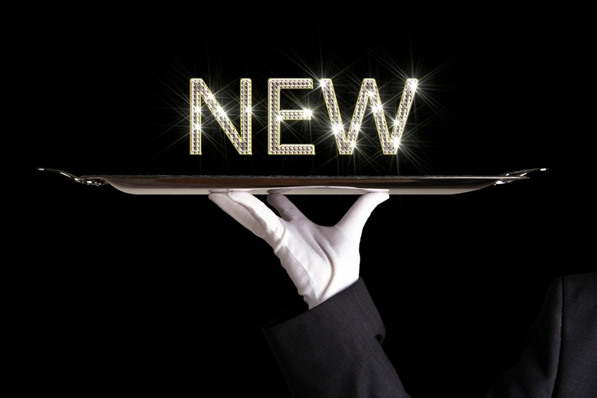 The word "new" on a silver platter held up by a gloved hand